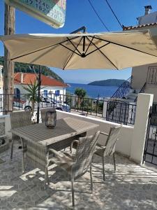 a table and chairs with an umbrella on a patio at Mariren in Neo Klima