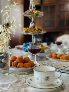 a table with plates of oranges and a cup of coffee at Uruyat Nomad guesthouse in Naryn