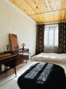 a bedroom with a piano and a bed with a rug at Uruyat Nomad guesthouse in Naryn