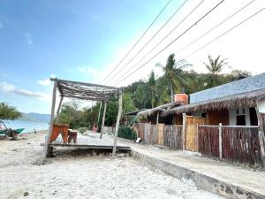 a house on the beach with a pavilion next to it at Pasir Homestay in Gili Gede +3 photos