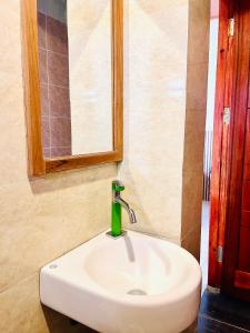 a white sink in a bathroom with a mirror at Pasir Homestay in Gili Gede