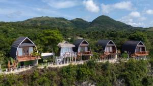 a row of huts on top of a hill at The Indah Cliff Sea View in Polilit