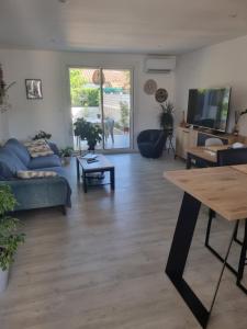 a living room with a couch and a table at Villa cocooning in Palavas-les-Flots