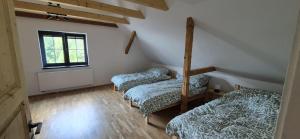 a room with three beds and a window at House by the water in Lesík