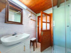a bathroom with a sink and a mirror and a shower at CAMPING A GRANDELLA in El Franco