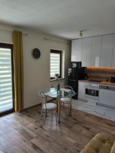 a kitchen with a glass table and chairs at Apartament przy Matce Polce in Łódź