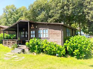a small house in a yard with bushes at CAMPING A GRANDELLA in El Franco