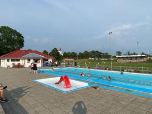 a large swimming pool with people playing in it at Spjutstorp's old school and rectory 2 in Tomelilla
