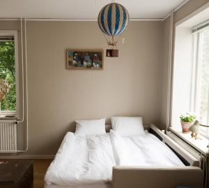 a bed with white sheets in a bedroom with a balloon at Spjutstorp's old school and rectory 2 in Tomelilla