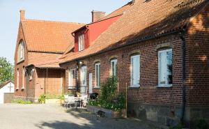 a brick house with a table and chairs in front of it at Spjutstorp's old school and rectory 2 in Tomelilla