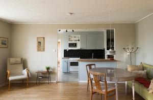 a kitchen and living room with a table and chairs at Spjutstorp's old school and rectory 2 in Tomelilla
