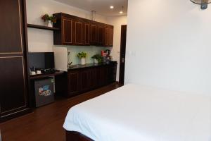 a bedroom with a white bed and a kitchen at A89 Hotel & Spa Hanoi in Hanoi +36 photos