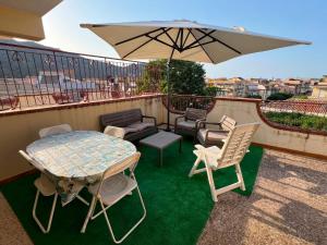 a table and chairs and an umbrella on a balcony at Lavinia House in Oliveri