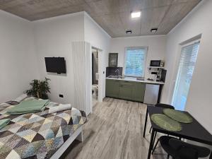 a bedroom with a bed and a table and a kitchen at Roma in Portorož