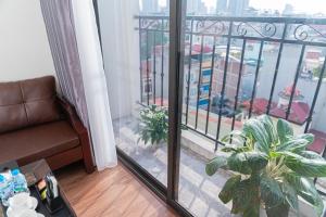 a living room with a view of a city from a balcony at A89 Hotel & Spa Hanoi in Hanoi