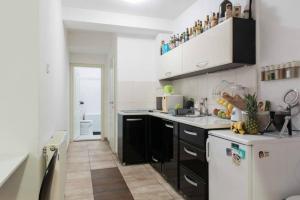 a kitchen with black and white cabinets and a sink at Spacious 1-bedroom apartment in Novi Sad
