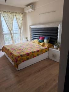 a bedroom with a large bed with a large window at Apartment for rent in Noida