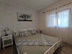 a bedroom with a bed with a tree on the wall at Apartment Velika obala in Bibinje