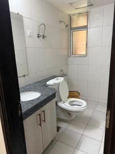 a bathroom with a toilet and a sink at Apartment for rent in Noida