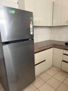 a stainless steel refrigerator in a kitchen at Apartment for rent in Noida +5 photos