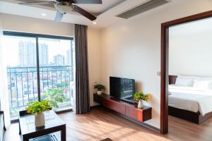 a bedroom with a bed and a tv and a balcony at A89 Hotel & Spa Hanoi in Hanoi