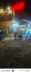 a man on a motorcycle in front of a store at night at AB lodge in Coimbatore