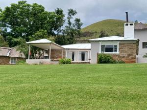 a house with a hill in the background at Ledges Retreat in Bergville