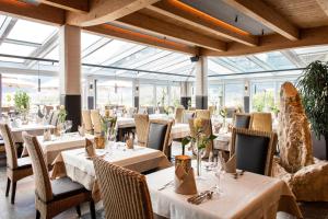 a restaurant with tables and chairs and glass ceilings at Hotel Hubertushof in Lermoos