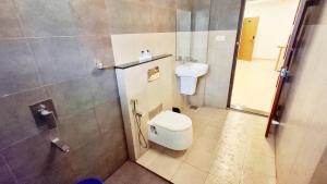 a bathroom with a toilet and a sink at Hotel Wayanad Gate in Wayanad