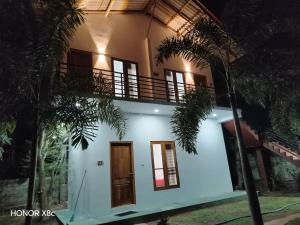 a house with a balcony on top of it at SA Resort in Anuradhapura