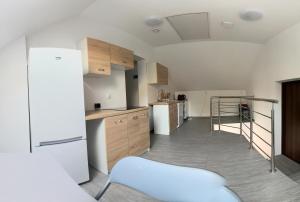 a kitchen with wooden cabinets and a white refrigerator at Agroturystyka u Aleksa in Krajno-Zagórze