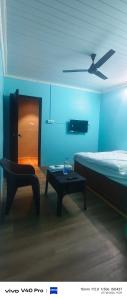 a blue room with a bed and a table and a chair at AB lodge in Coimbatore