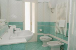 a bathroom with a white sink and a toilet at gardeniapartment in Minori +10 photos