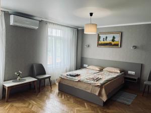 ein Schlafzimmer mit einem Bett, einem Tisch und einem Fenster in der Unterkunft У Палыча in Cahul