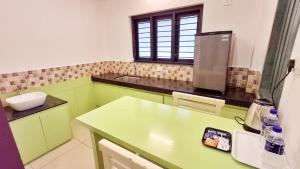 a kitchen with green cabinets and a counter top at Hotel Wayanad Gate in Wayanad