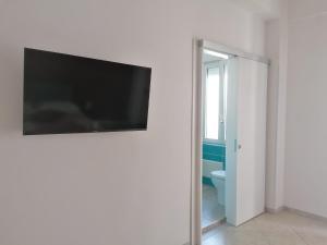 a flat screen tv hanging on a wall in a bathroom at Stilla Chjara in Reggio di Calabria