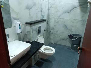 a bathroom with a white toilet and a sink at Hotel Deepjot in Karnal