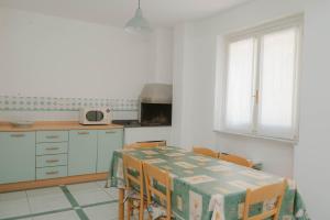 a kitchen with a table and some chairs and a window at gardeniapartment in Minori