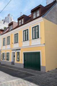 a yellow and white building with a garage at Miki Stays - 700m zum Ring in Vienna