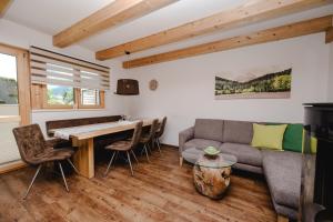 a living room with a table and a couch at Chalets AurAlpin in Kleinarl