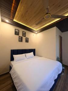 a bedroom with a large white bed in a room at Lagoon Bites in Jhājra