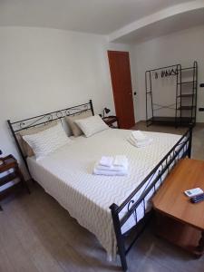 a bedroom with a large bed with two towels on it at B&B ombra dei pini in San Leucio del Sannio