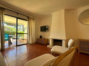a living room with a fireplace and a television at Solar Pinheiros RC in Vilamoura