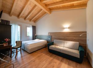 a bedroom with a bed and a couch and a desk at Agriturismo al Comarel in Tarzo