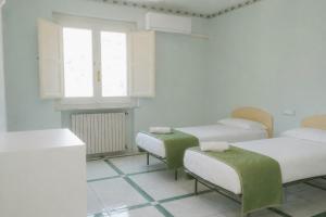 a hospital room with three beds and a window at gardeniapartment in Minori