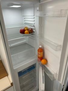 an open refrigerator with apples and oranges and a bottle of orange juice at FBC Roms Business in Rødby