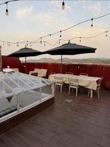 a patio with tables and chairs and umbrellas at Sherezade Riad in Tétouan