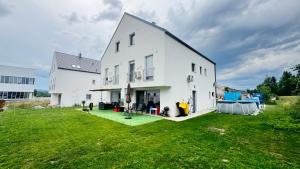 a large white house with a large yard at Villa AMULET - Spacious 3BR Villa near Postojna Cave in Postojna