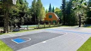 a basketball court in a yard with a fence at Howard Lodge & Spa in Saint Adolphe D'Howard