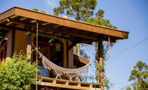 a tree house with a hammock in front of it at Pousada Ritmos da Terra - Estadia de 6ª a Domingo in Angelina